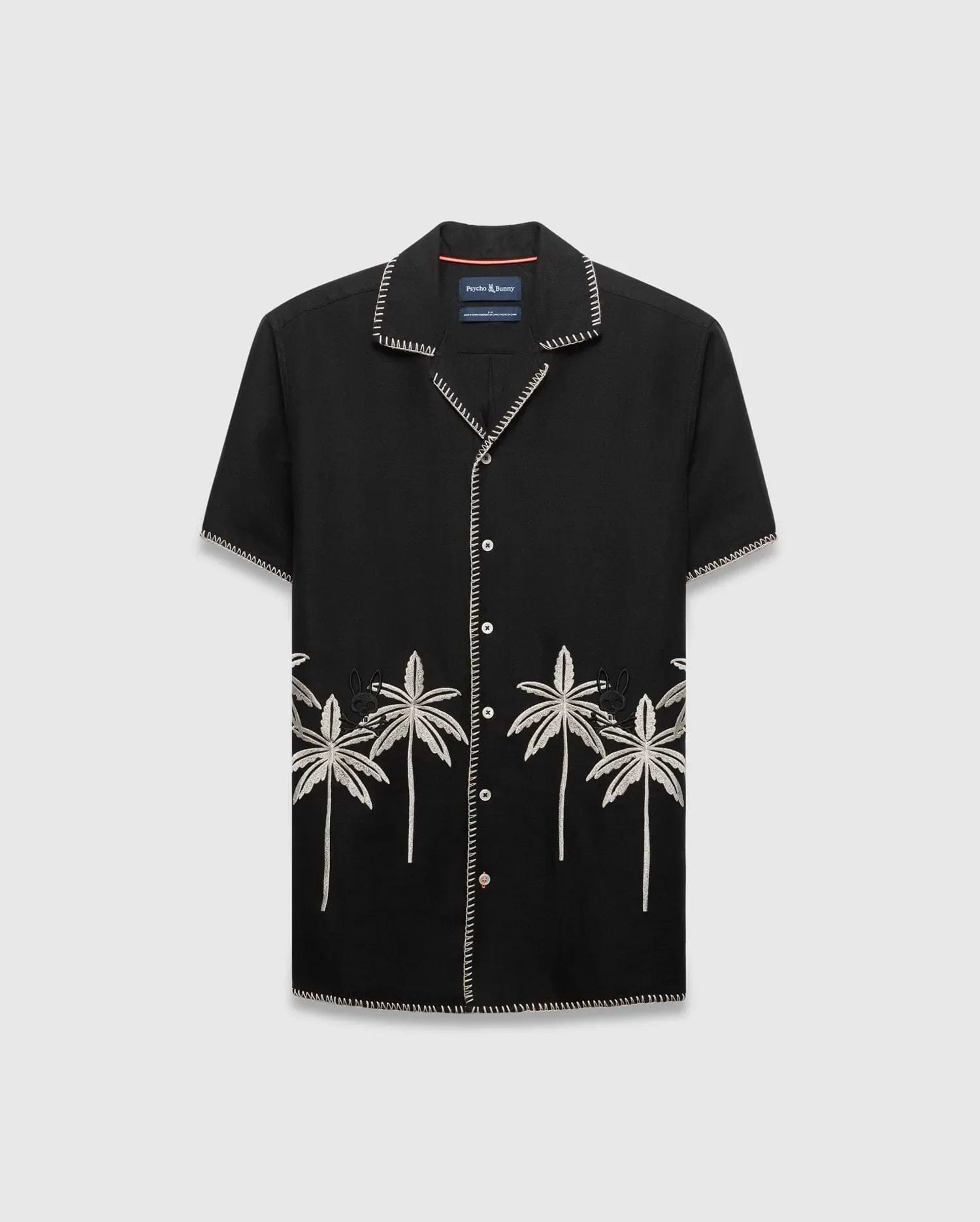 Mens Brad Linen Shirt, a black relaxed-fit camp collar shirt with white contrast stitching, embroidered light grey palm trees, and a small black Psycho Bunny skull logo.