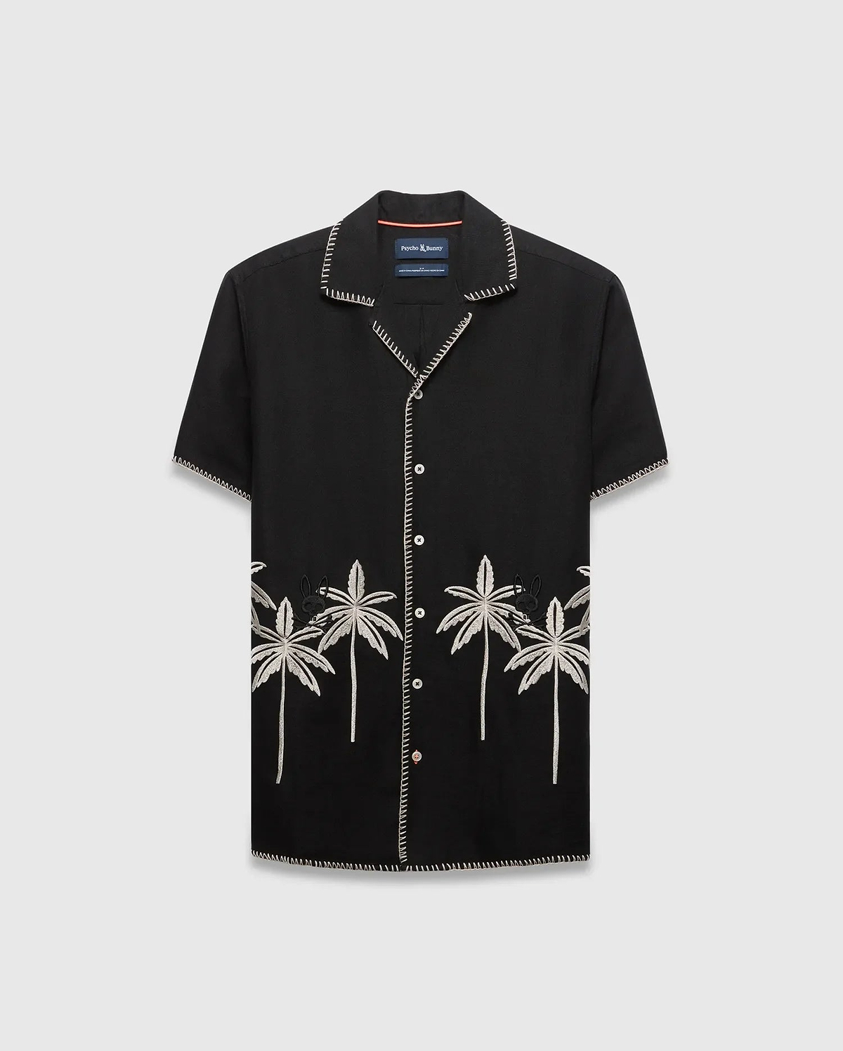 Mens Brad Linen Shirt, a black relaxed-fit camp collar shirt with white contrast stitching, embroidered light grey palm trees, and a small black Psycho Bunny skull logo.