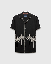 Mens Brad Linen Shirt, a black relaxed-fit camp collar shirt with white contrast stitching, embroidered light grey palm trees, and a small black Psycho Bunny skull logo.