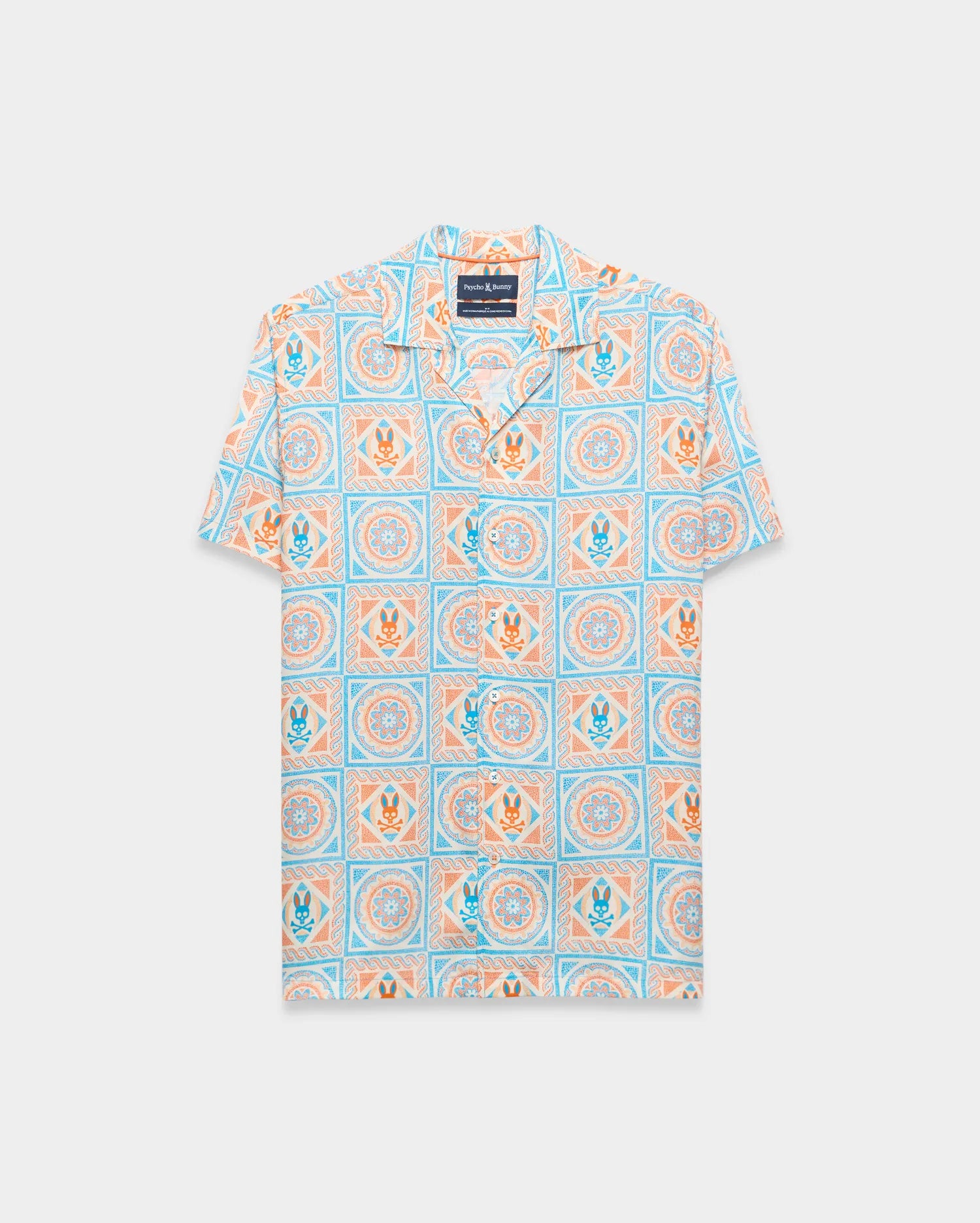 Mens Frank Tencel Shirt, a relaxed fit short-sleeve camp collar shirt in light blue, orange, and cream with an all-over tiled pattern featuring Psycho Bunny skull logos and floral designs.