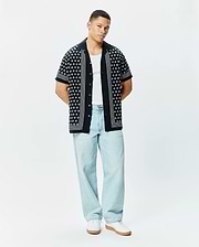 Mens Nick Tencel Shirt, a black short-sleeve camp collar shirt with a white geometric pattern, vertical white stripes on the placket and sleeve cuffs, and a relaxed fit.