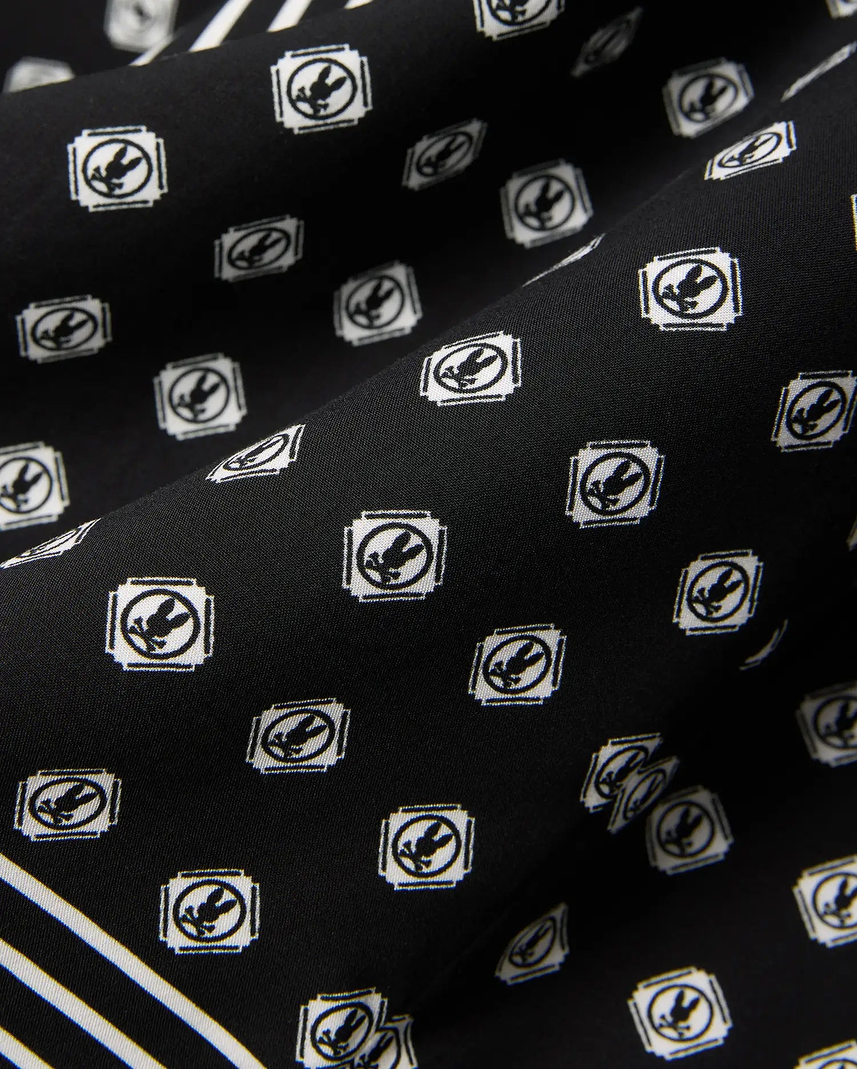 Mens Nick Tencel Shirt in black, featuring a white all-over Psycho Bunny skull logo pattern within square frames and white accent stripes on smooth tencel fabric.