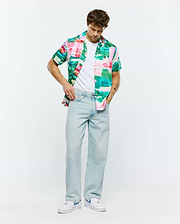 Psycho Bunny Mens Nate Tencel Shirt, a relaxed fit short-sleeve button-up with a vibrant abstract brushstroke pattern in pink, green, teal, and white, embodying refined streetwear.