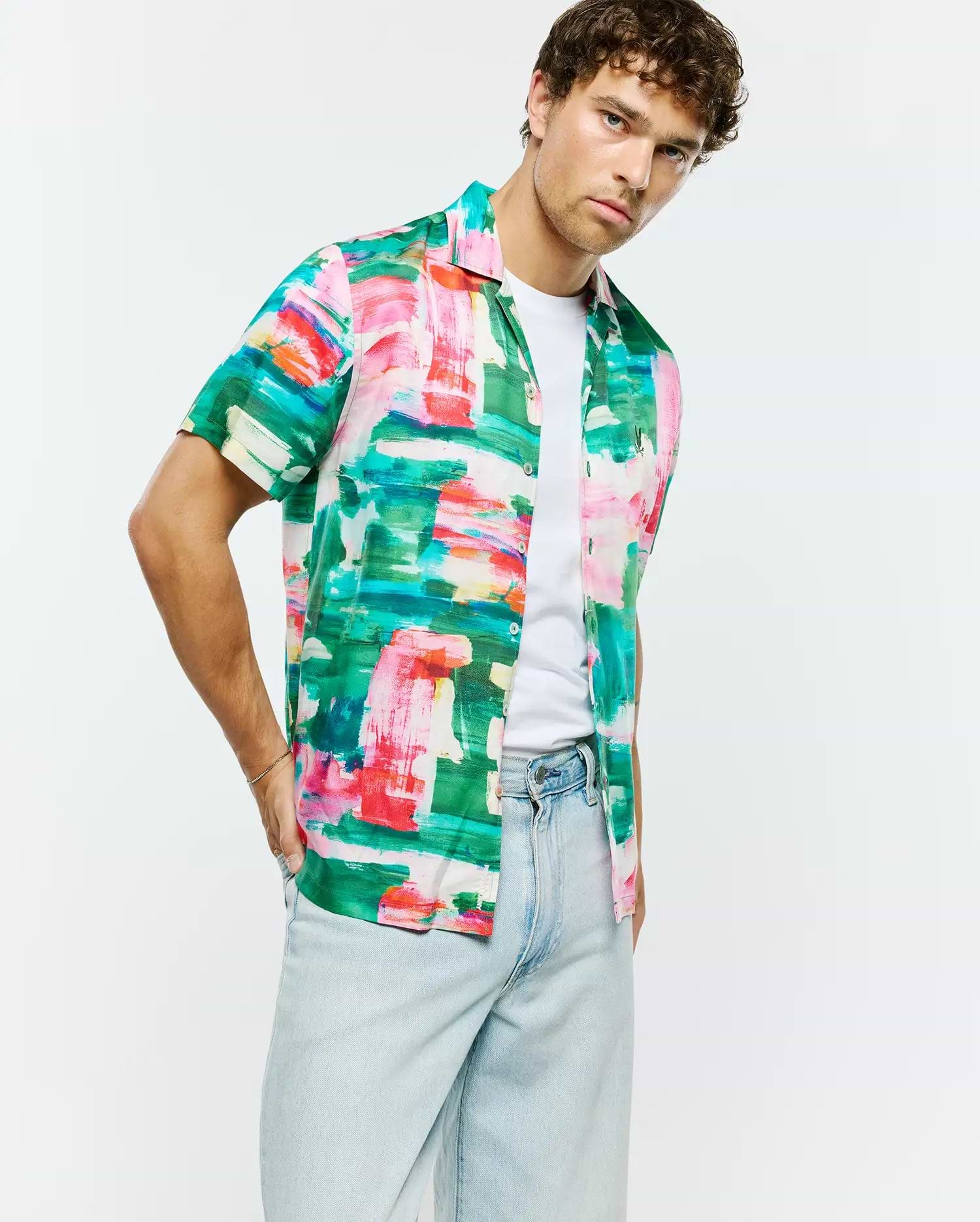 Vibrant green, pink, red, blue, white abstract brushstroke print Mens Nate Tencel Shirt. Relaxed short-sleeve, smooth Tencel fabric, with a small embroidered Psycho Bunny skull logo on the left chest.