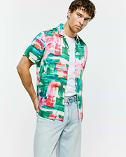 Vibrant green, pink, red, blue, white abstract brushstroke print Mens Nate Tencel Shirt. Relaxed short-sleeve, smooth Tencel fabric, with a small embroidered Psycho Bunny skull logo on the left chest.
