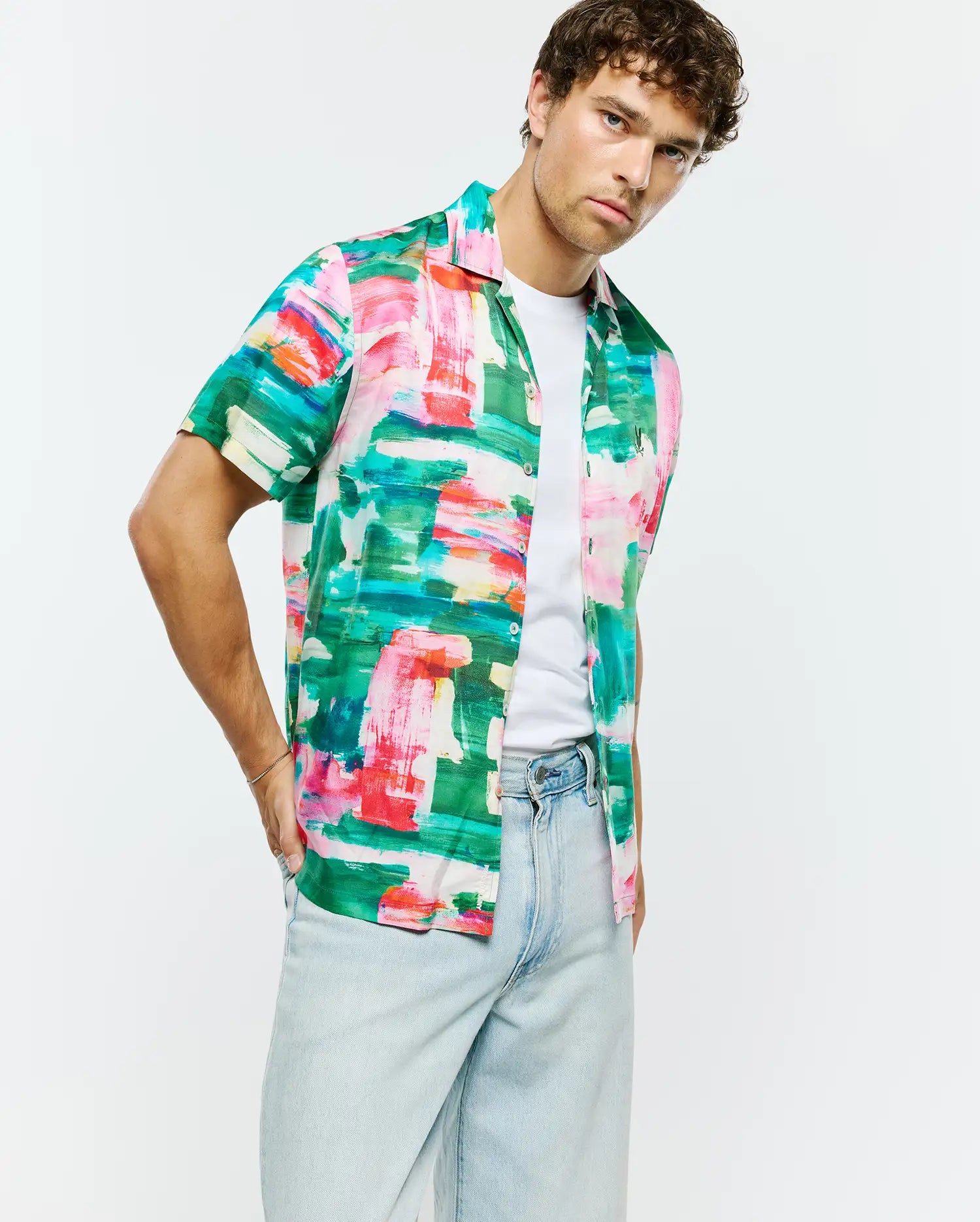 Vibrant green, pink, red, blue, white abstract brushstroke print Mens Nate Tencel Shirt. Relaxed short-sleeve, smooth Tencel fabric, with a small embroidered Psycho Bunny skull logo on the left chest.