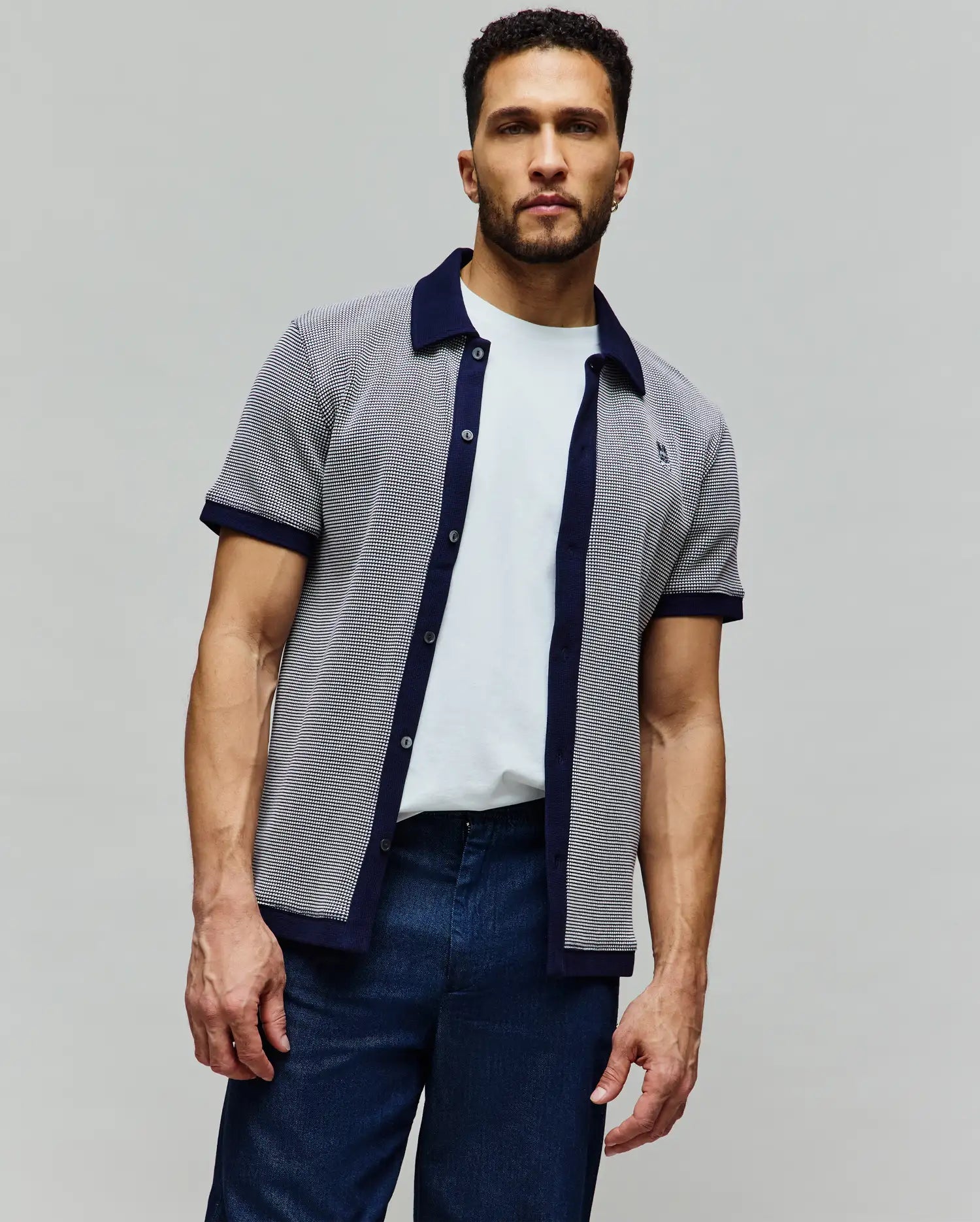 Mens Maxton Waffle Shirt, a classic fit short-sleeve button-up in a white and navy micro-patterned waffle knit, featuring a navy collar, placket, and cuffs, with a small embroidered Psycho Bunny skull logo on the left chest.