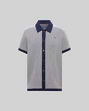 Mens Maxton Waffle Shirt, a classic fit short-sleeve knit polo in black and white micro-pattern with navy collar, placket, cuffs, and hem, featuring a small embroidered Psycho Bunny skull logo on the left chest.