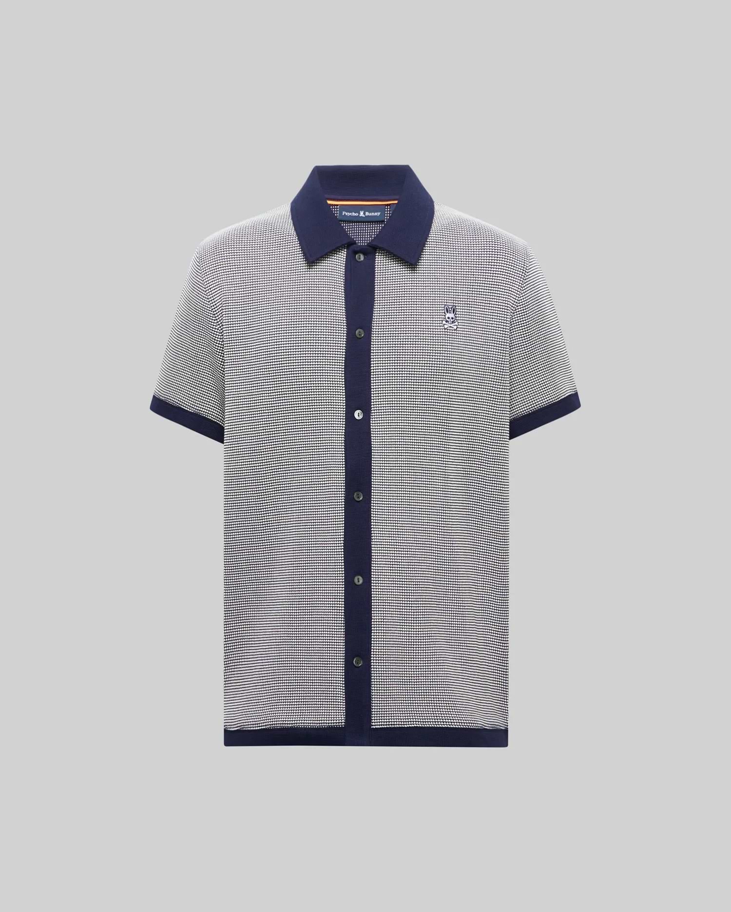 Mens Maxton Waffle Shirt, a classic fit short-sleeve knit polo in black and white micro-pattern with navy collar, placket, cuffs, and hem, featuring a small embroidered Psycho Bunny skull logo on the left chest.