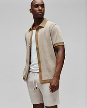 Mens Maxton Waffle Shirt, a relaxed fit short-sleeve collared shirt in a beige waffle knit with tan accents on the collar, placket, and cuffs, featuring a small embroidered Psycho Bunny skull logo on the left chest.