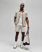 Mens Maxton Waffle Shirt, a relaxed fit beige waffle knit short-sleeve shirt with brown collar and placket, featuring a small embroidered Psycho Bunny logo on the left chest, paired with light beige drawstring shorts.