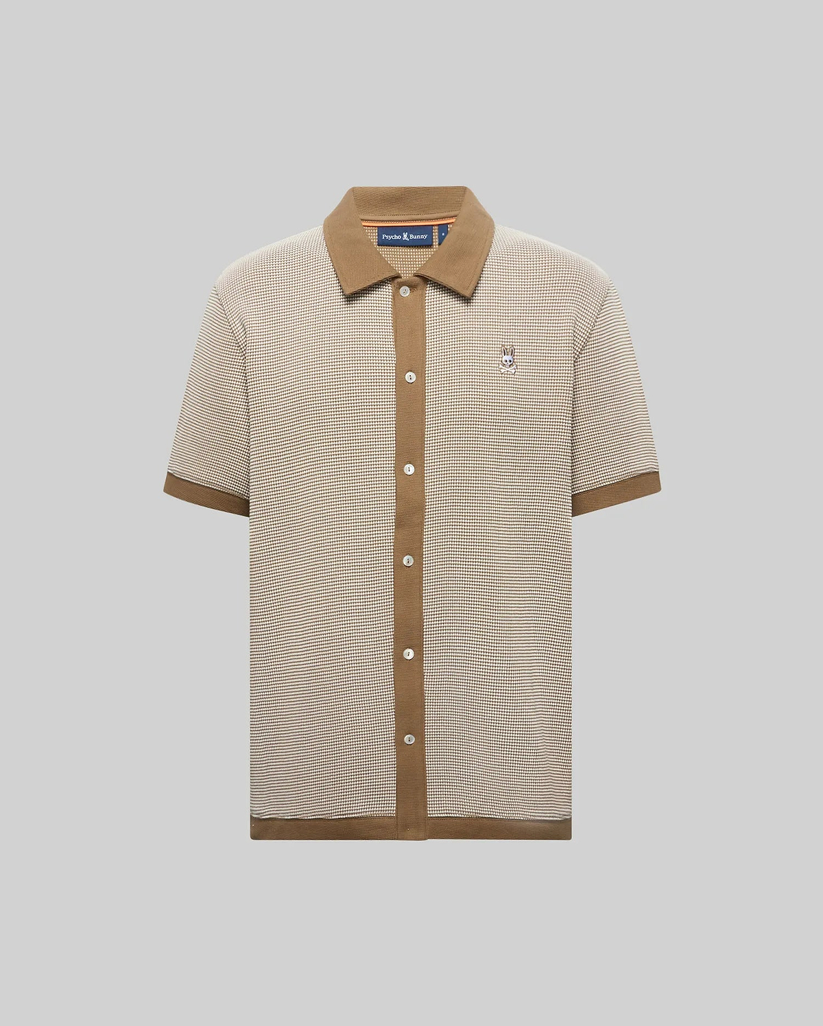 Mens Maxton Waffle Shirt, a classic fit beige and brown micro-check waffle knit shirt with a solid brown ribbed collar, full button placket, cuffs, hem, and an embroidered Psycho Bunny skull logo on the left chest.