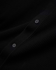 Mens Yann Knit Shirt, a sleek black premium ribbed knit garment, detailed with two dark buttons featuring the Psycho Bunny brand name embossed in a lighter tone. (6)
