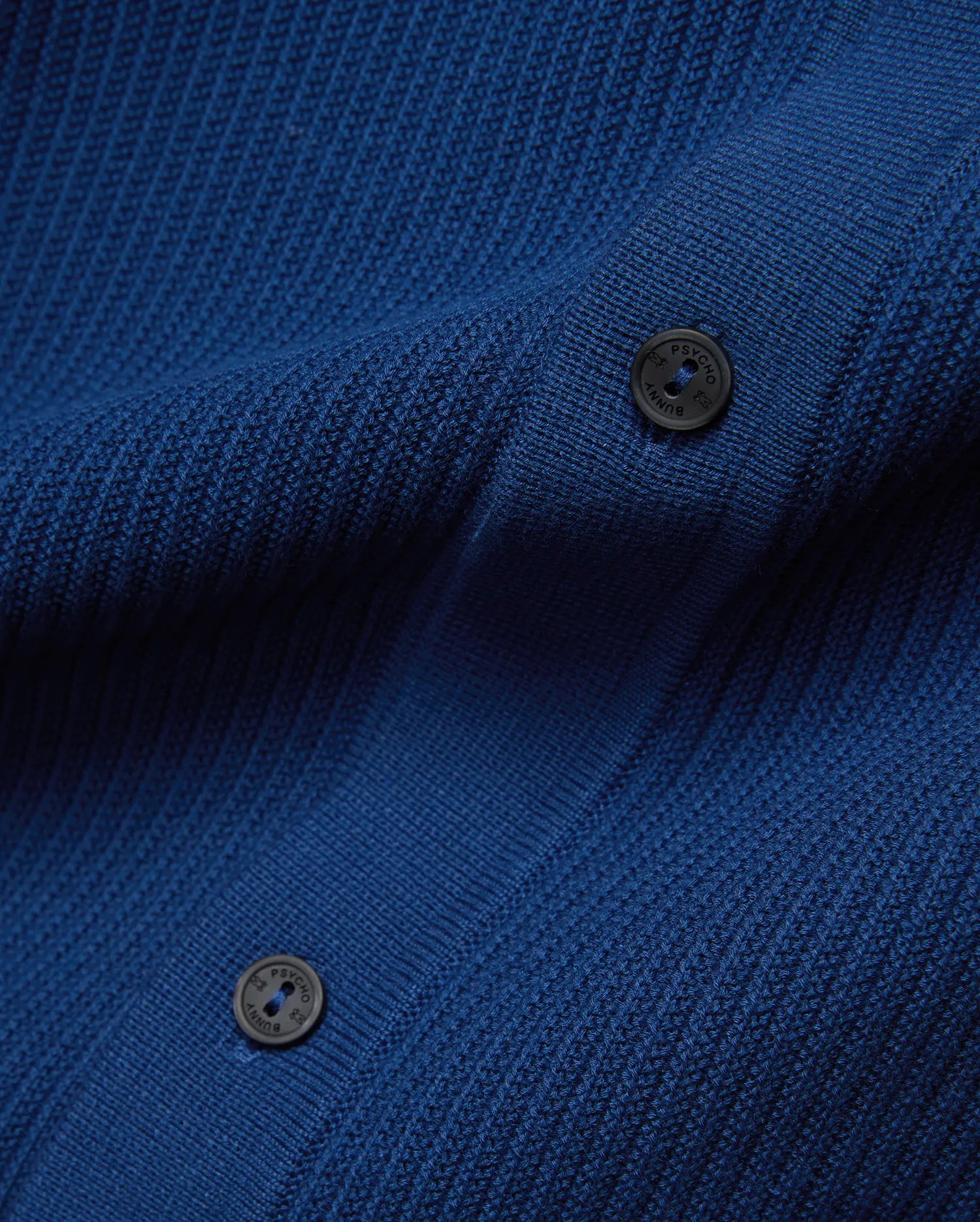 Mens Yann Knit Shirt in vibrant royal blue, featuring a premium, refined, subtly textured knit fabric and dark, branded Psycho Bunny buttons. (6)