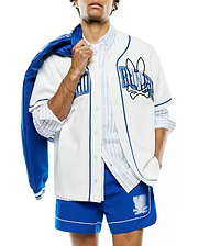 Mens Nathaniel Baseball Shirt, a relaxed fit white jersey with royal blue piping and buttons. Large embroidered Psycho Bunny skull logo and BUNNY text on chest. Royal blue shorts with white piping and a large Psycho Bunny logo.