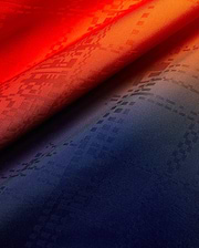 Mens Zander Jacquard Shirt fabric showcasing a vibrant red to deep navy gradient, subtly woven with an all-over Psycho Bunny skull logo jacquard pattern.