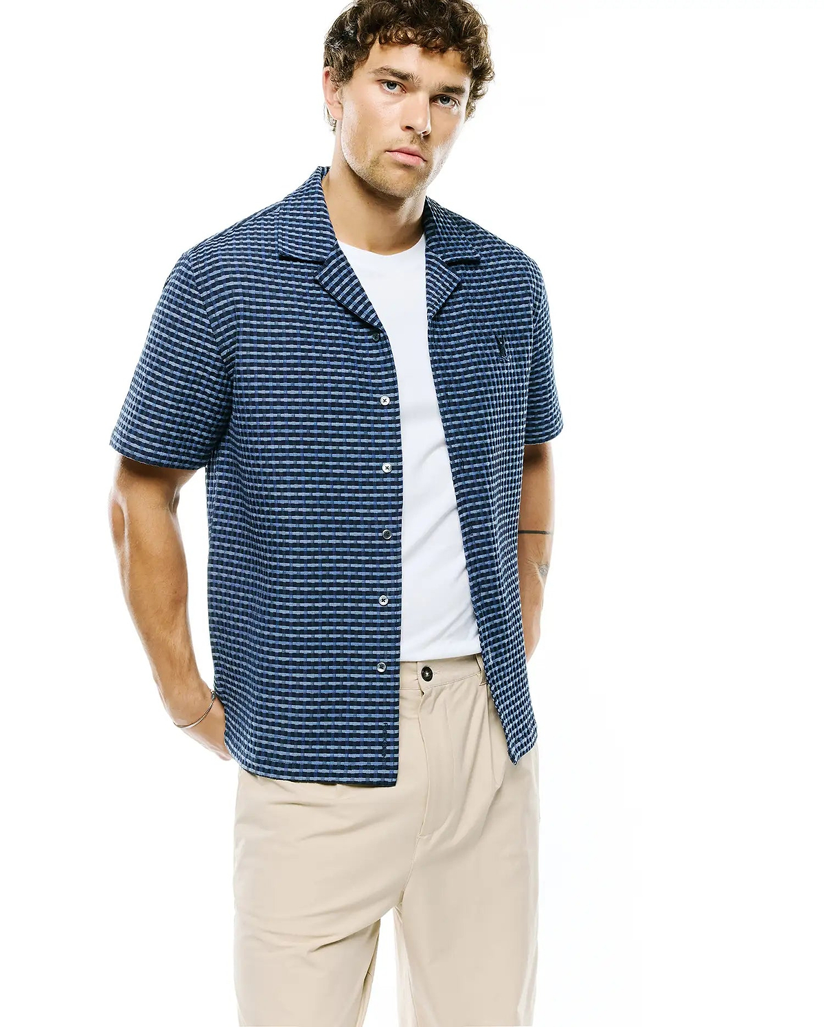 Mens Erik Raised Check Shirt: Relaxed fit navy and light blue textured short-sleeve shirt with a camp collar, featuring a subtle raised check pattern and a small embroidered Psycho Bunny skull logo on the left chest. (1)