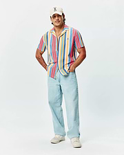 Mens Hubert Knit Shirt, a relaxed fit, short-sleeve, multi-color striped knit shirt featuring a camp collar and small embroidered Psycho Bunny logo on the left chest.