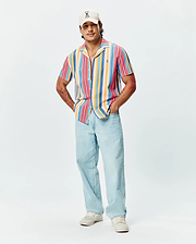 Mens Hubert Knit Shirt, a relaxed fit, short-sleeve, multi-color striped knit shirt featuring a camp collar and small embroidered Psycho Bunny logo on the left chest.
