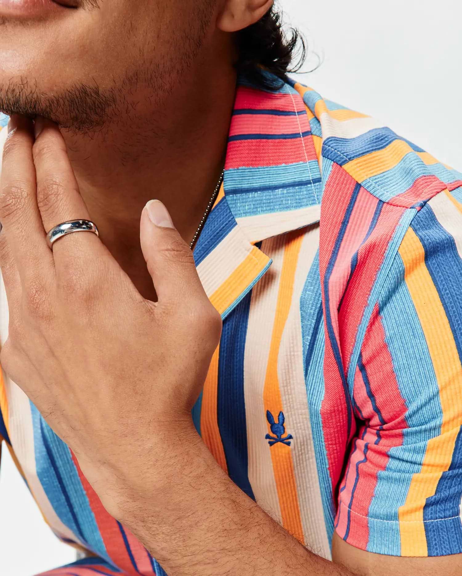 Mens Hubert Knit Shirt, a classic fit, multi-colored vertical striped textured knit shirt with an embroidered Psycho Bunny skull logo on the left chest.