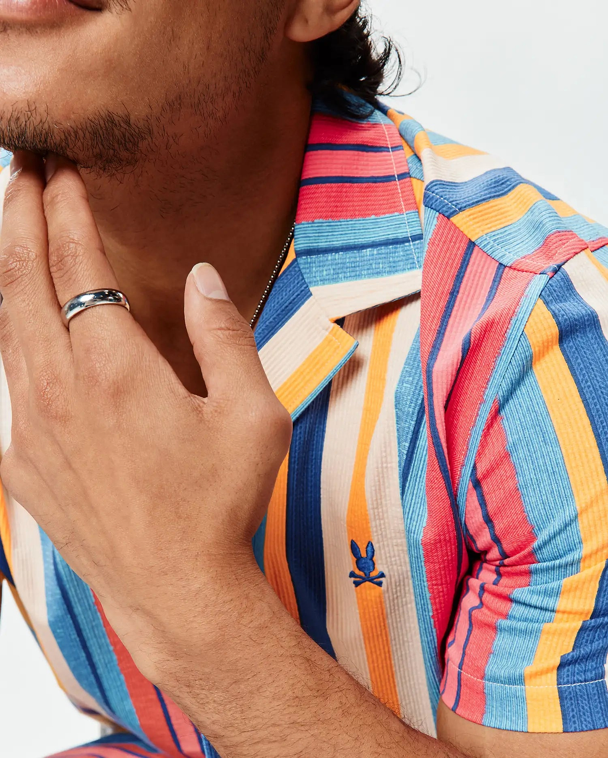 Mens Hubert Knit Shirt, a classic fit, multi-colored vertical striped textured knit shirt with an embroidered Psycho Bunny skull logo on the left chest.