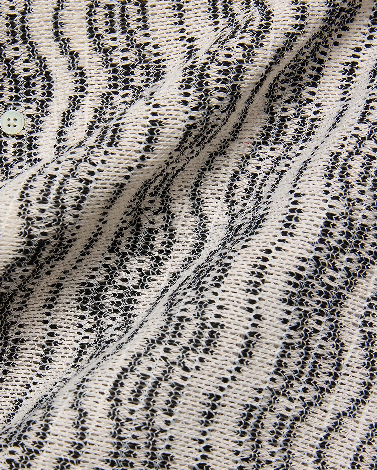 Mens Dave Crochet Shirt featuring an intricate open-weave knit in cream and black, forming a textured striped pattern, with a visible light button closure.