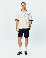 Mens Kelly Oversized Shirt in cream, a short-sleeve button-up with a relaxed fit, featuring a contrasting navy blue camp collar and cuffs, and an embroidered Psycho Bunny skull logo on the left chest.