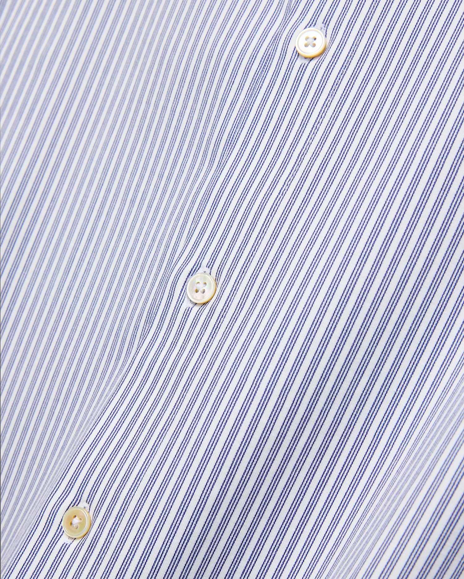Mens Jim Stripe Jersey Knit L/s Shirt, a premium white long-sleeve shirt featuring fine blue vertical pinstripes and lustrous mother-of-pearl buttons, reflecting refined streetwear aesthetics.
