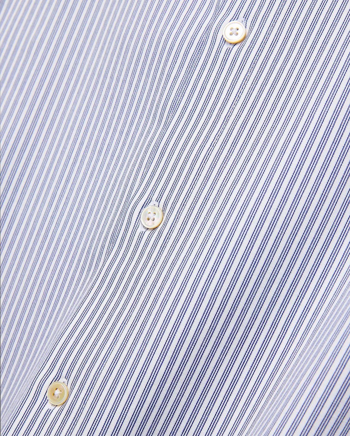 Mens Jim Stripe Jersey Knit L/s Shirt, a premium white long-sleeve shirt featuring fine blue vertical pinstripes and lustrous mother-of-pearl buttons, reflecting refined streetwear aesthetics.