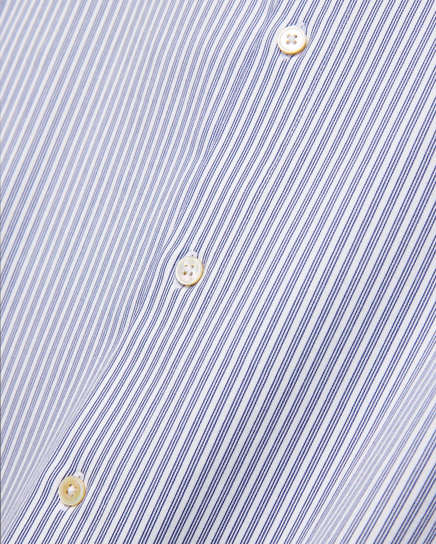 Mens Jim Stripe Jersey Knit L/s Shirt, a premium white long-sleeve shirt featuring fine blue vertical pinstripes and lustrous mother-of-pearl buttons, reflecting refined streetwear aesthetics.