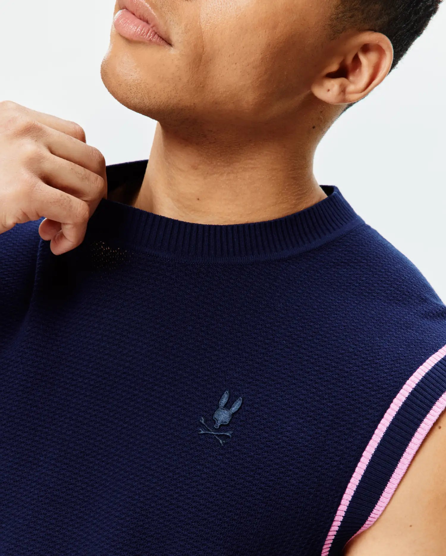 Mens Peter Knit Vest in navy textured knit, featuring a small embroidered Psycho Bunny skull logo on the left chest and ribbed armholes with pink and navy stripes.