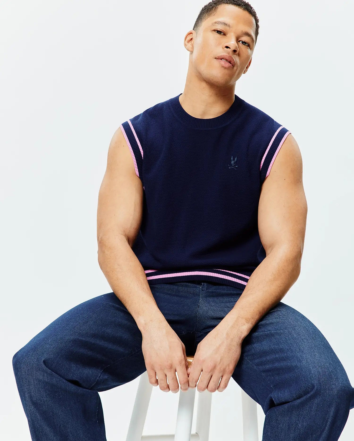 Navy Mens Peter Knit Vest with a classic fit, featuring a textured knit fabric, pink and white striped trim on armholes and hem, and a small embroidered Psycho Bunny skull logo on the left chest.