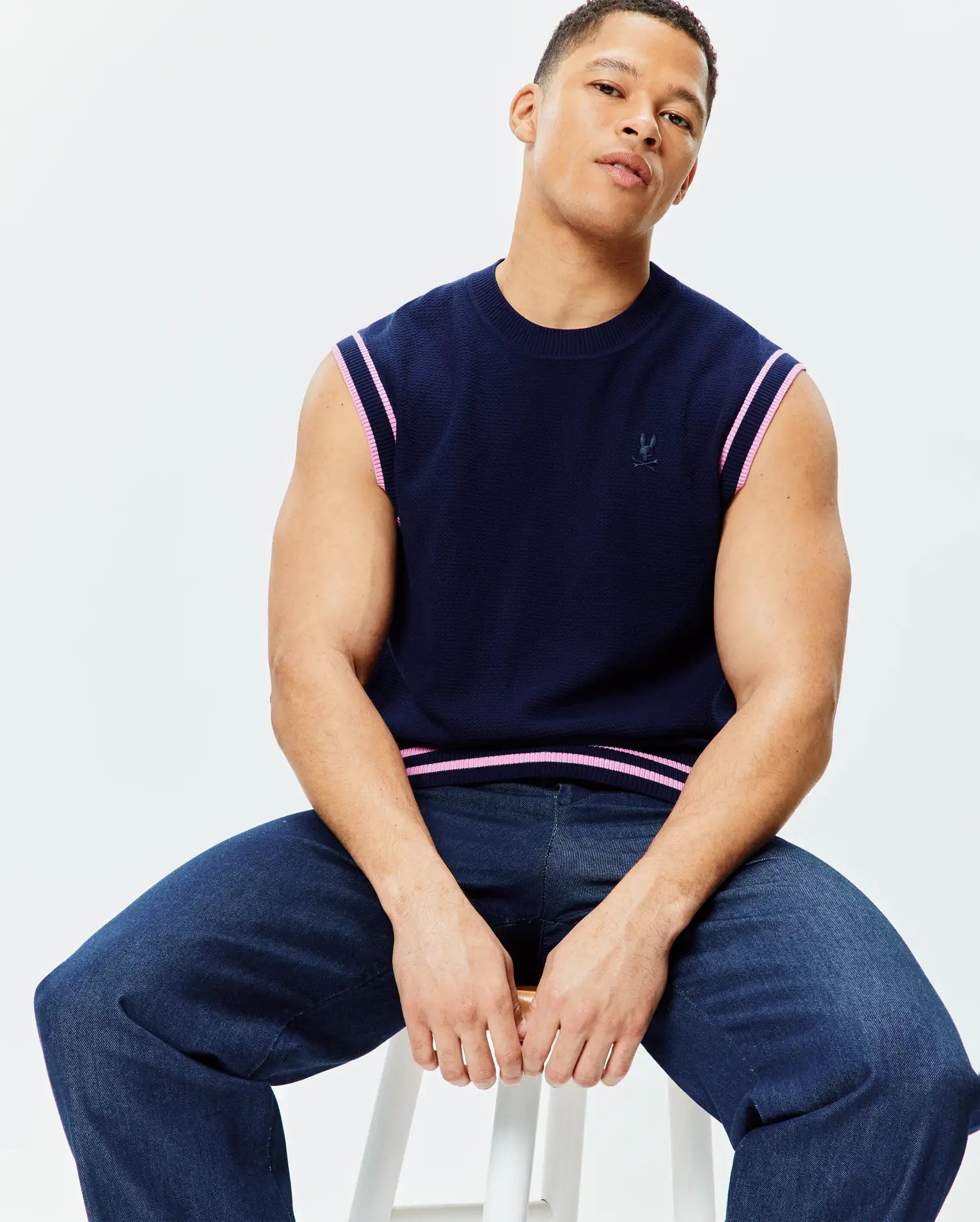 Navy Mens Peter Knit Vest with a classic fit, featuring a textured knit fabric, pink and white striped trim on armholes and hem, and a small embroidered Psycho Bunny skull logo on the left chest.