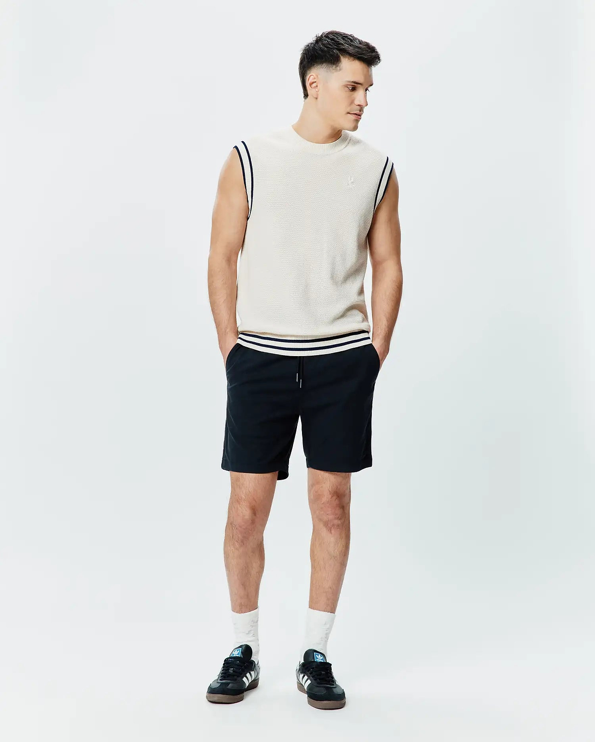 Mens Peter Knit Vest in cream, featuring a classic fit, textured knit fabric, navy and white striped ribbed armholes and hem, with a small embroidered Psycho Bunny skull logo on the left chest.
