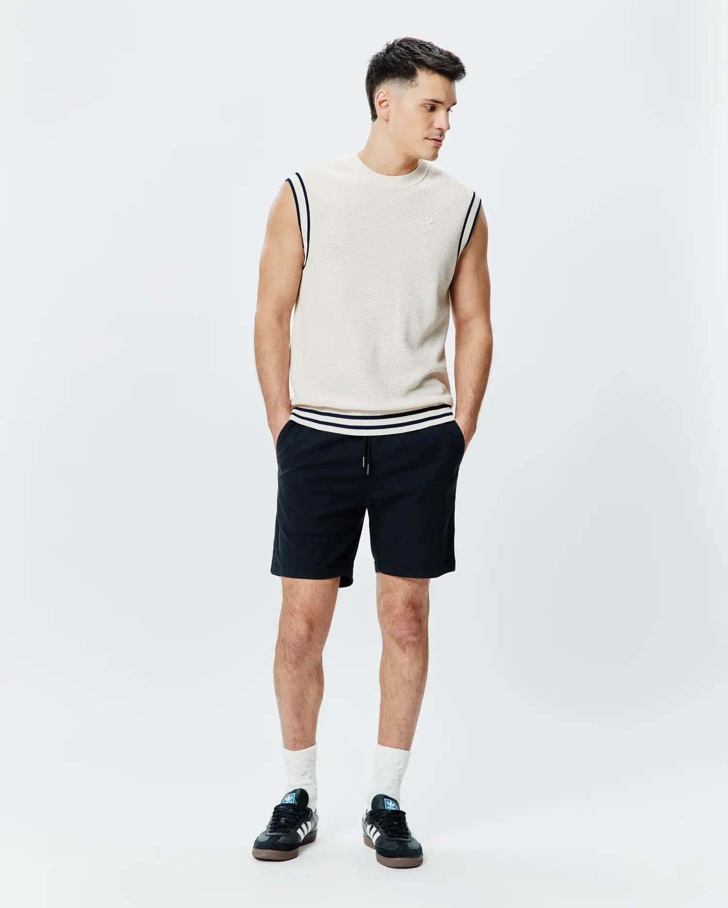Mens Peter Knit Vest in cream, featuring a classic fit, textured knit fabric, navy and white striped ribbed armholes and hem, with a small embroidered Psycho Bunny skull logo on the left chest.