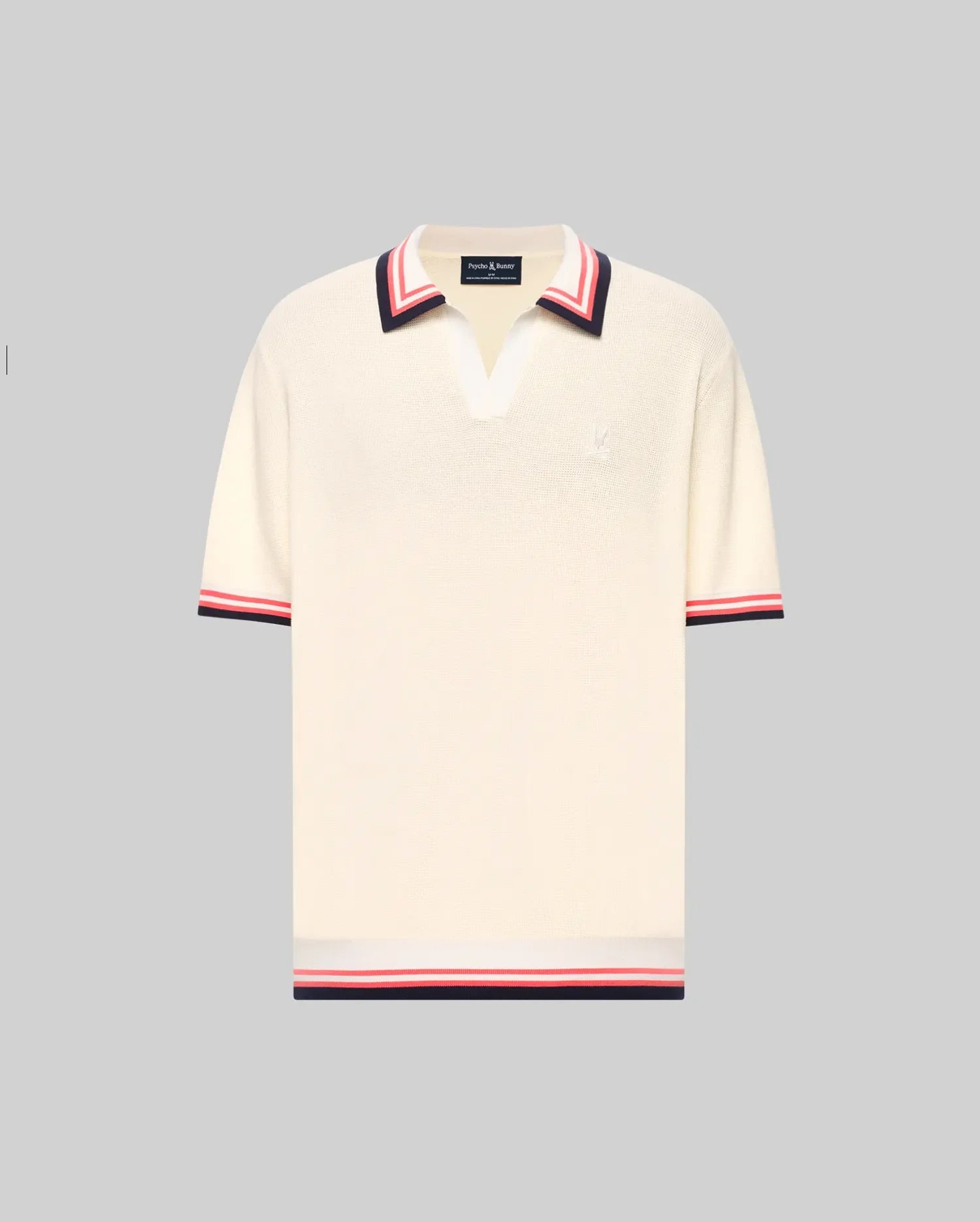 The Psycho Bunny MENS CARTER JOHNNY COLLAR KNIT POLO (MT0400093) is a cream, 100% cotton short-sleeve polo with a deep V-neck Johnny collar and red/navy colorblocked stripes on the collar, sleeves, and hem, shown on a light gray background. (5)
