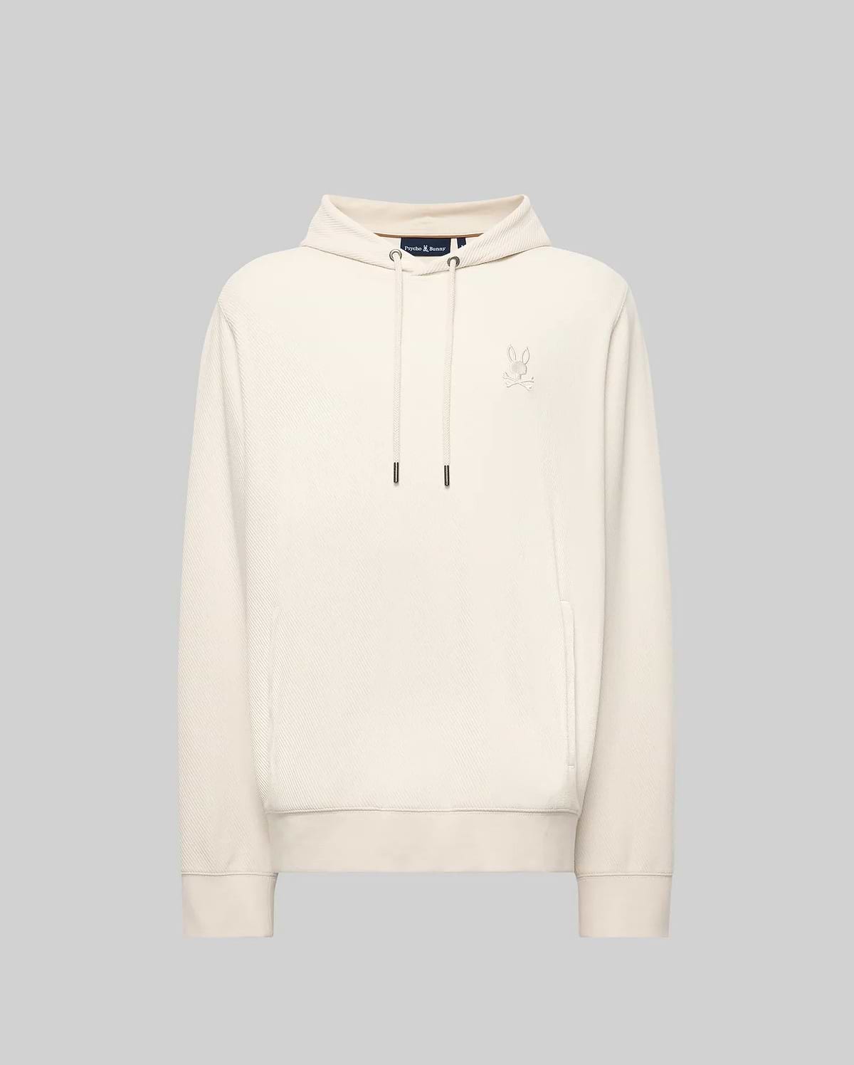 The MENS KAI TWILL TEXTURE HOODIE - MT0500019 by Psycho Bunny features a cream color, drawstrings, a small embroidered Bunny logo on the left chest, and ribbed cuffs and hem, shown against a light gray background.