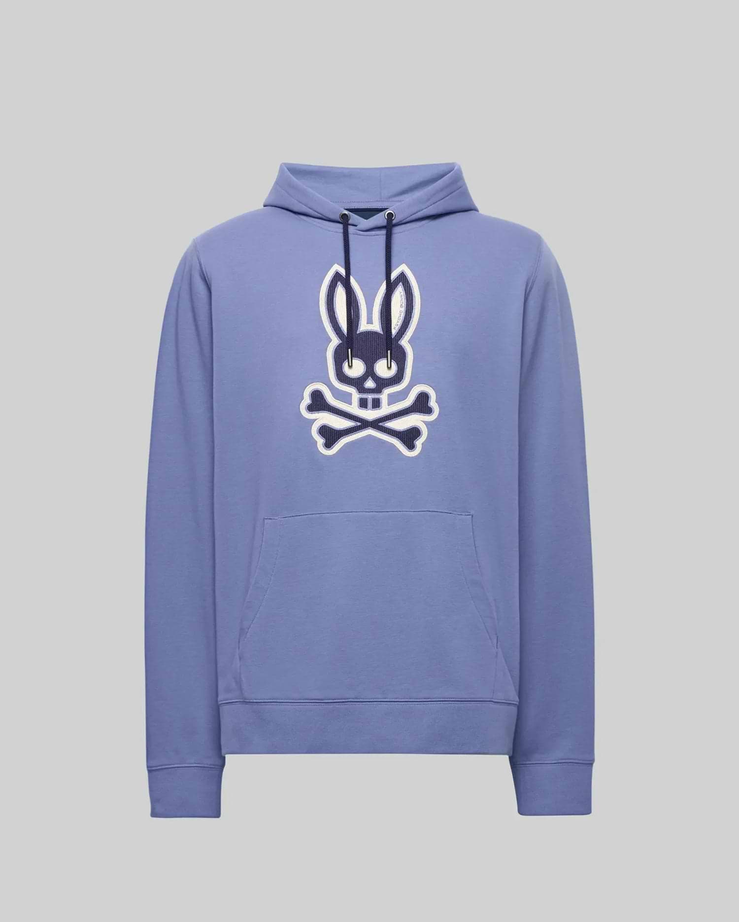 The Psycho Bunny MENS RYDER EMBROIDERED BUNNY PATCH HOODIE - MT0500029 is a light purple hoodie with a front pocket, featuring a large black and white Bunny patch above crossed bones—ideal for cozy loungewear.