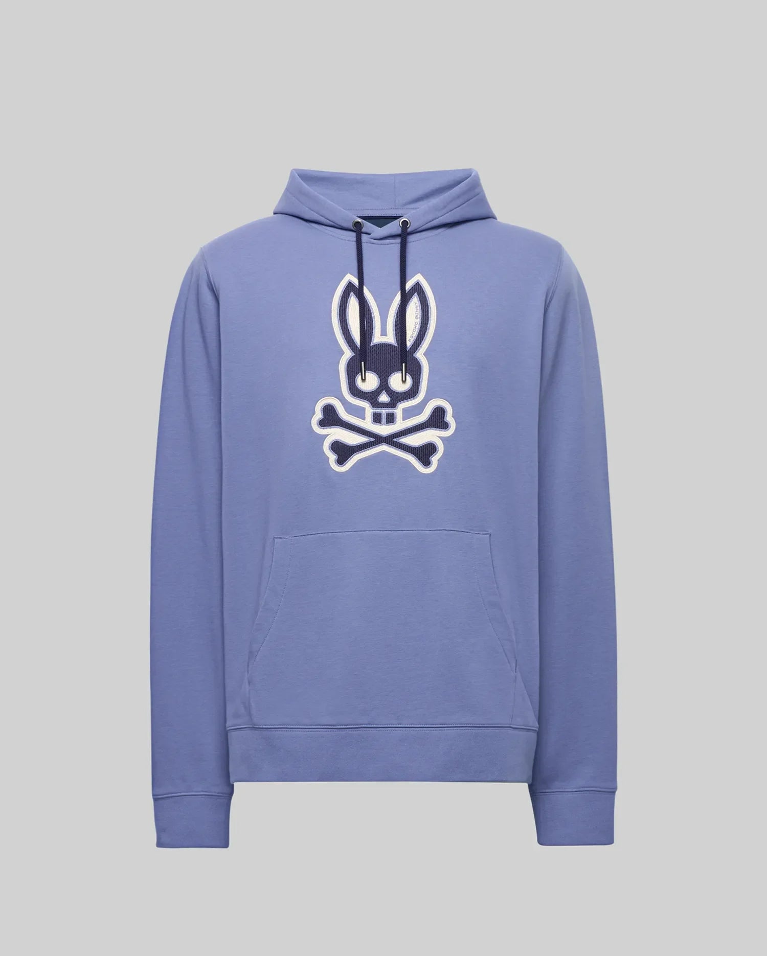 The Psycho Bunny MENS RYDER EMBROIDERED BUNNY PATCH HOODIE - MT0500029 is a light purple hoodie with a front pocket, featuring a large black and white Bunny patch above crossed bones—ideal for cozy loungewear.