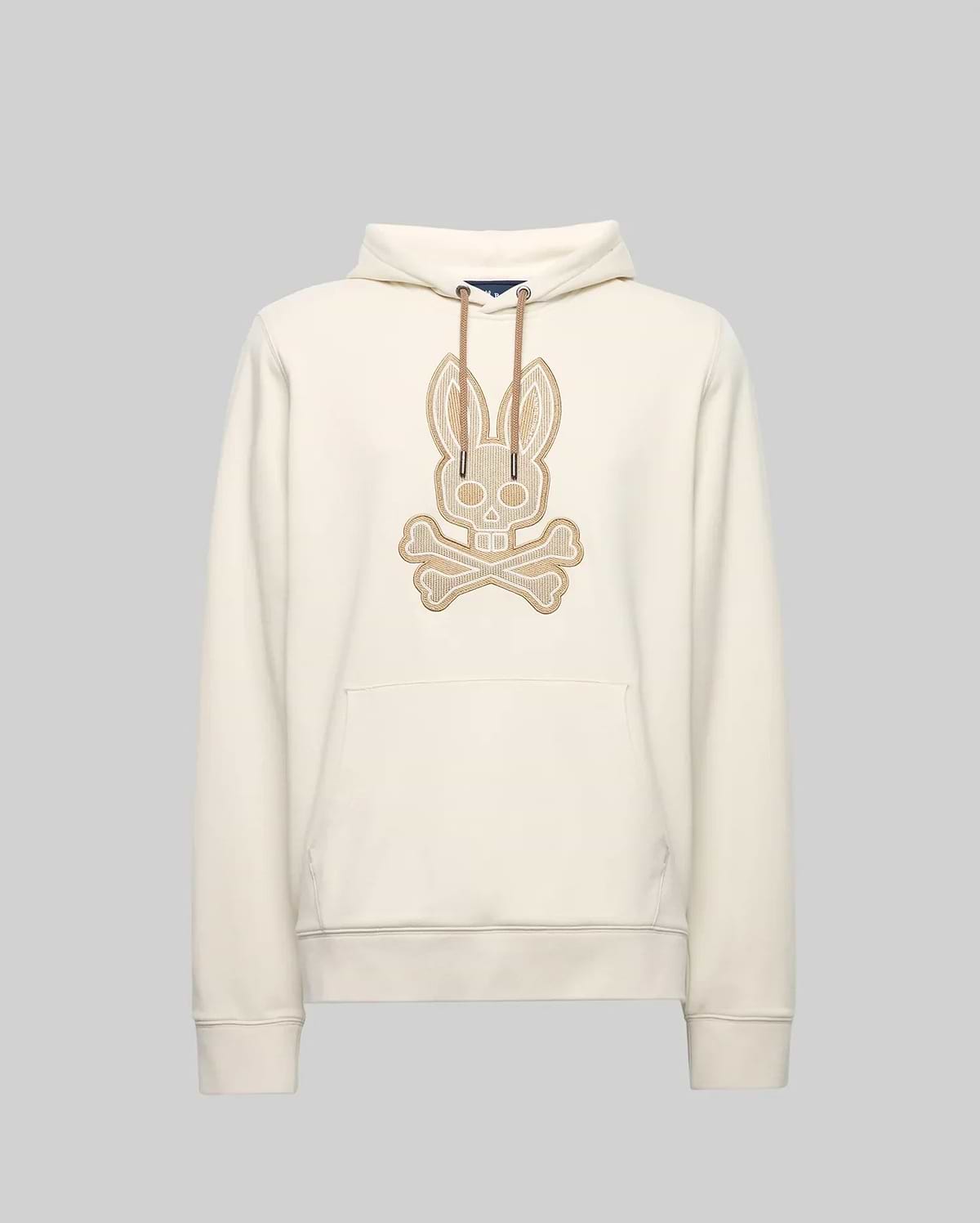 The Psycho Bunny MENS RYDER EMBROIDERED BUNNY PATCH HOODIE (MT0500029) is a cream-colored hoodie with a front pocket, drawstring hood, and large embroidered bunny skull and crossbones patch—ideal for cozy loungewear style.