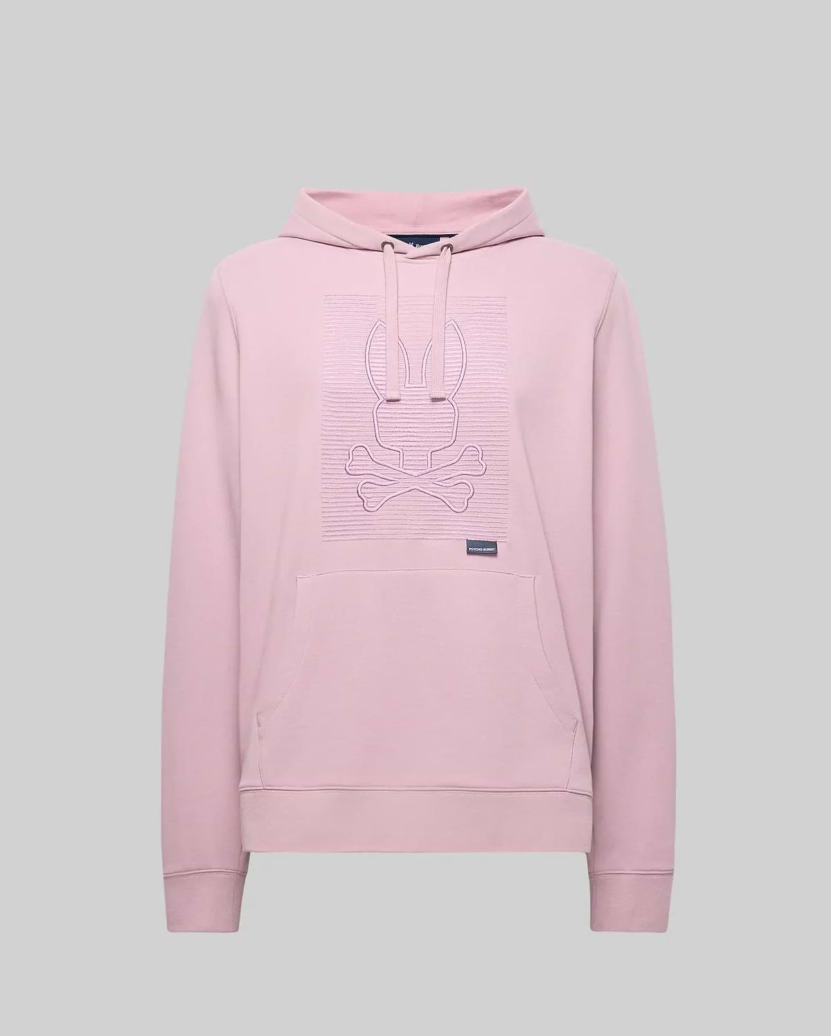 The Psycho Bunny MENS GRANT HOODIE - MT0500032 is a light pink premium cotton-blend hoodie with long sleeves, a front pocket, and a raised zig-zag embroidered bunny head above crossed bones on the chest. Plain gray background.
