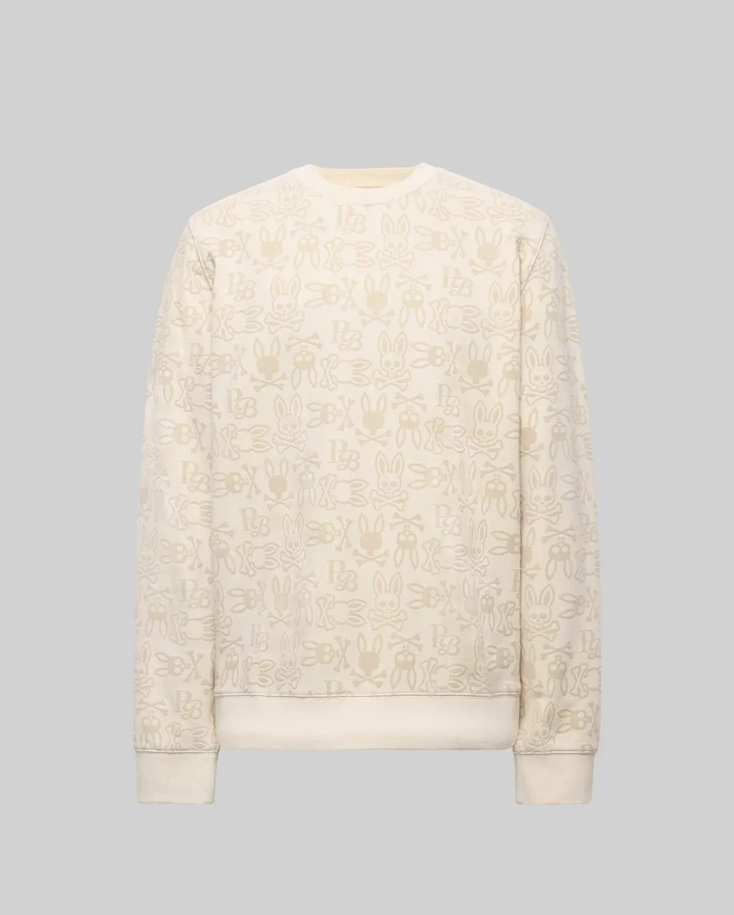 The Psycho Bunny MENS REED FLOCK CREW (MT0500041) is a premium cotton blend cream crewneck pullover, featuring a beige cartoon bunny pattern and "SBX" text on a plain gray background.