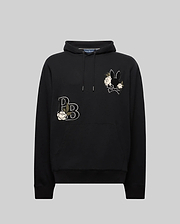The Psycho Bunny MENS AUGUSTE HOODIE (MT0500043) is a black regular fit hoodie with a drawstring hood, chenille floral details, stylized "PB" letters, and a floral bunny design on the upper left chest, shown on a plain gray background.