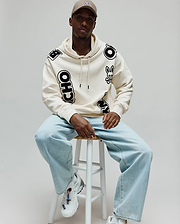 Mens Toby Oversized Hoodie in cream, featuring scattered large black Psycho Bunny skull logos and bold PSYCHO BUNNY lettering, with a relaxed fit and soft fleece texture. (3)