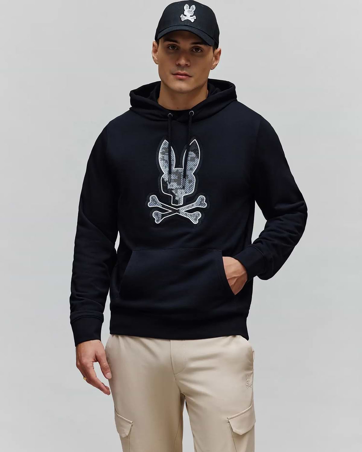 Mens Olivier Embroidered Hoodie, a black classic fit french terry hoodie featuring a large central embroidered Psycho Bunny skull logo with a grey and white camouflage pattern and a front kangaroo pocket.