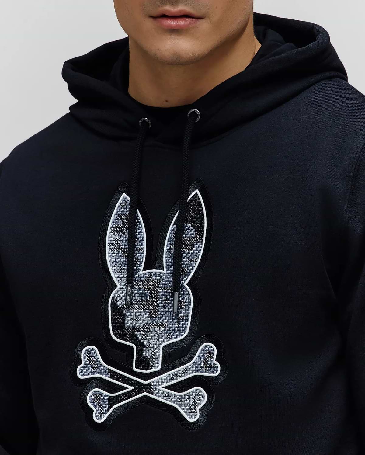 Black Mens Olivier Embroidered Hoodie, classic fit French terry, with a drawstring hood and large central chest embroidered Psycho Bunny skull logo featuring a grey geometric pattern and white outline.