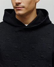 Black Mens Dustin Hoodie in a relaxed fit, featuring a unique textured knit with an all-over embossed Psycho Bunny skull and geometric square pattern. (2)