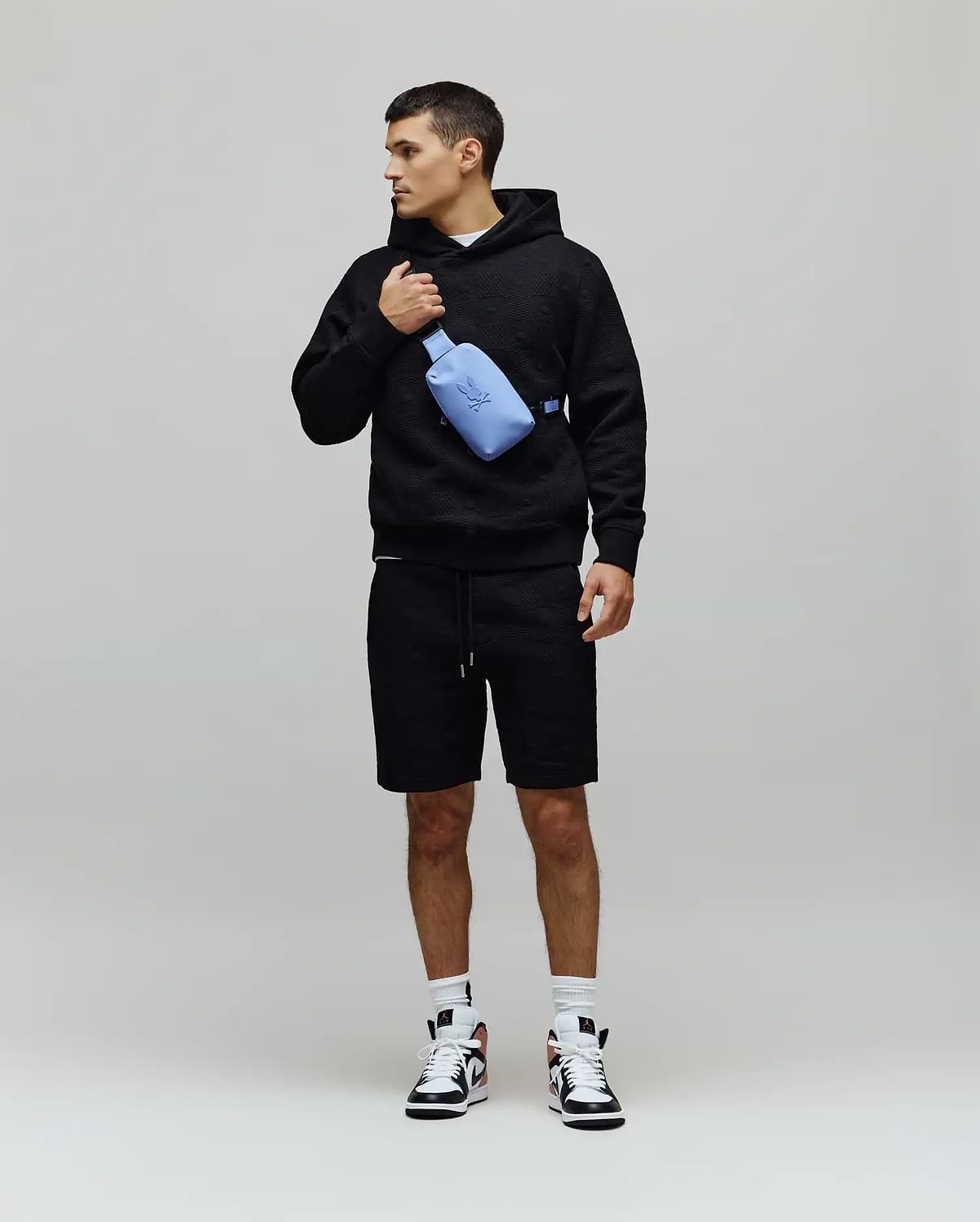 Mens Dustin Hoodie, a black relaxed-fit textured knit hoodie featuring an allover embossed pattern, drawstring hood, and a small embroidered Psycho Bunny skull logo on the left chest. (4)