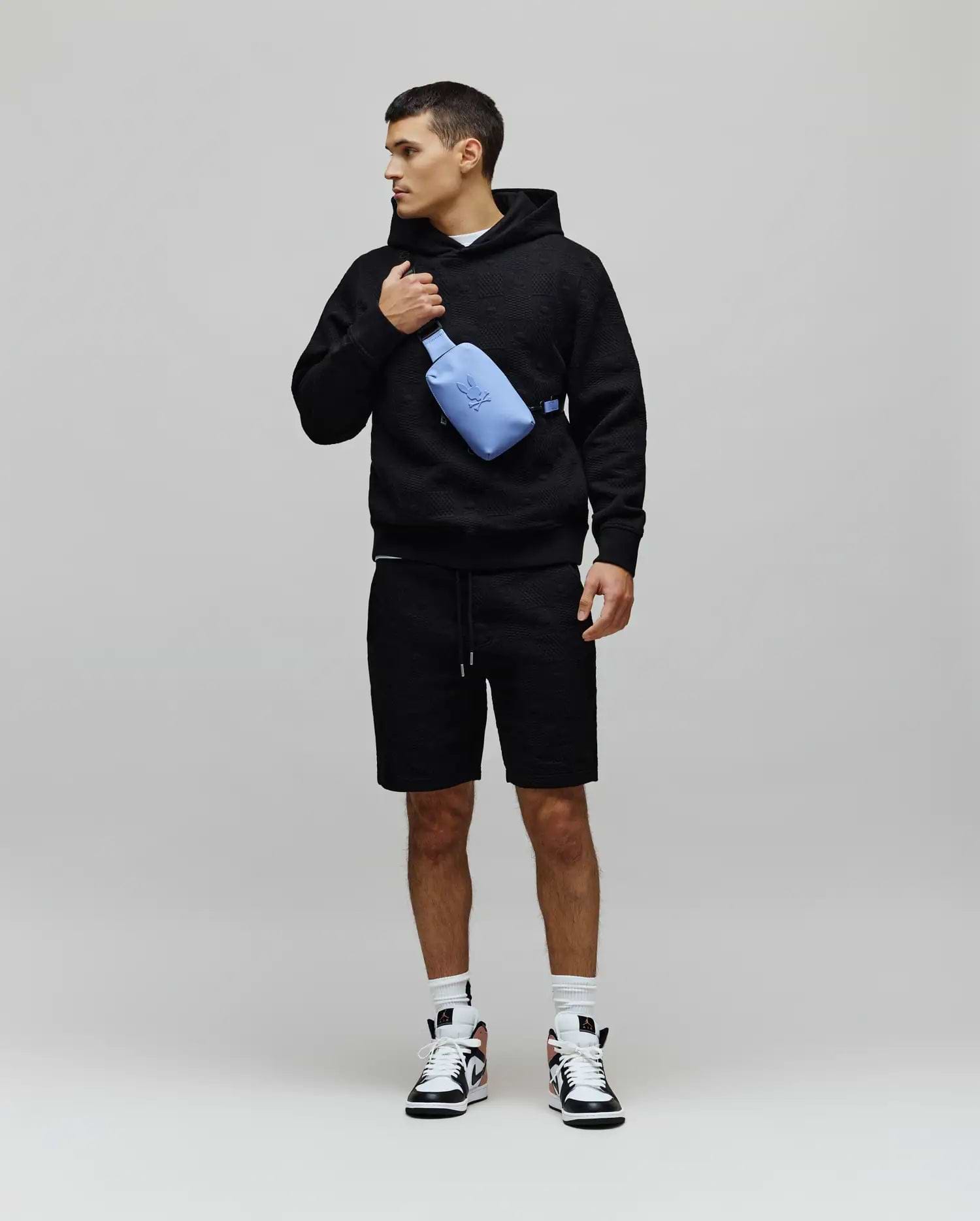 Mens Dustin Hoodie, a black relaxed-fit textured knit hoodie featuring an allover embossed pattern, drawstring hood, and a small embroidered Psycho Bunny skull logo on the left chest. (4)