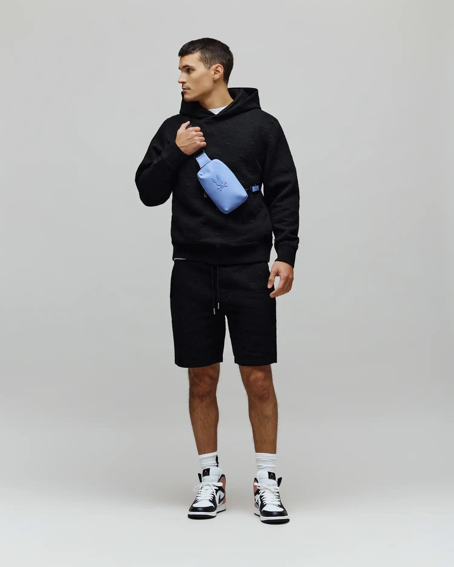 Mens Dustin Hoodie, a black relaxed-fit textured knit hoodie featuring an allover embossed pattern, drawstring hood, and a small embroidered Psycho Bunny skull logo on the left chest. (4)